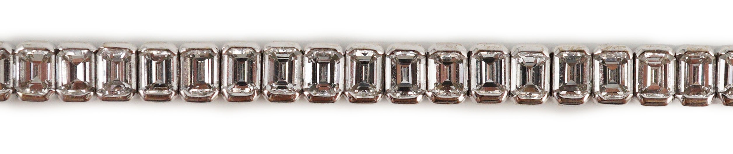 A modern 18ct white gold and emerald cut diamond set line bracelet
